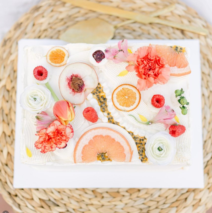 Aerial view of artisan flat cake with citrus slices and fresh flowers